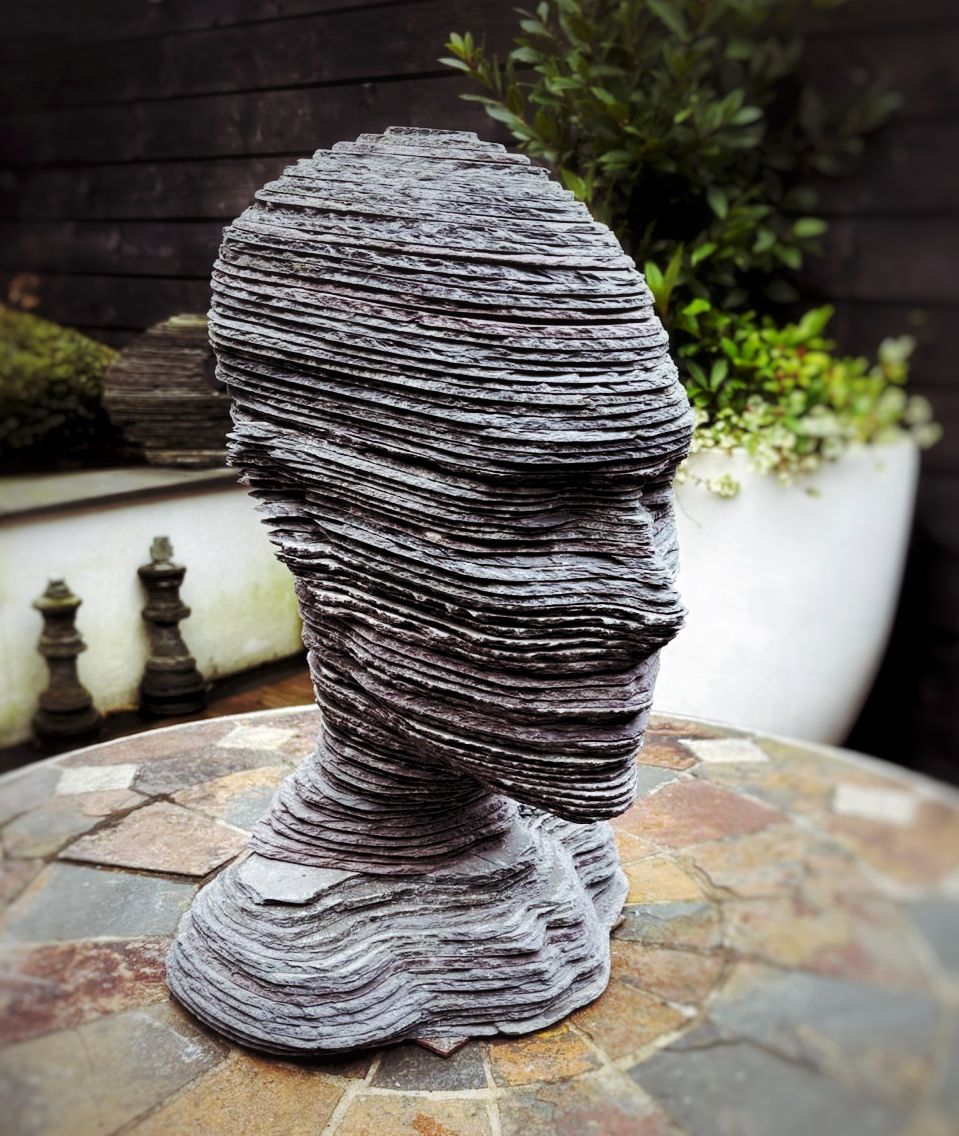 Sculptural human head and bust made from layered slate